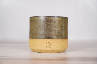 Autumn Green dark green glaze candle on light brown speckled ceramic vessel, front view