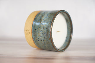 Rutile blue glaze candle on light brown ceramic vessel, second view
