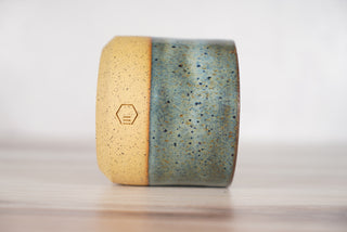 Rutile blue glaze candle on light brown ceramic vessel, third view