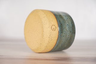Rutile blue glaze candle on light brown ceramic vessel, fourth view