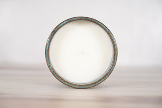 Rutile blue glaze candle on light brown ceramic vessel, fifth view