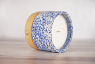 Speckled blue glaze candle on light brown ceramic vessel, second view
