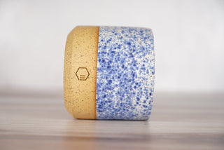 Speckled blue glaze candle on light brown ceramic vessel, third view