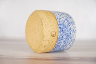 Speckled blue glaze candle on light brown ceramic vessel, fourth view
