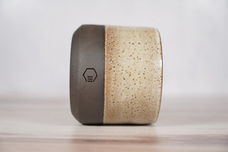Embers speckled beige and brown glaze candle on dark brown ceramic vessel, third view