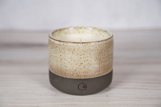 Embers speckled beige and brown glaze candle on dark brown ceramic vessel, viewed from above