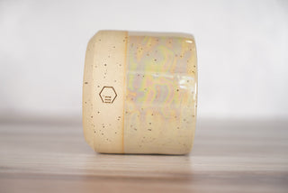 Mother of pearl glaze on light brown speckled ceramic candle vessel, third view