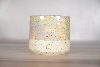 Mother of pearl glaze on white speckled ceramic candle vessel, front view
