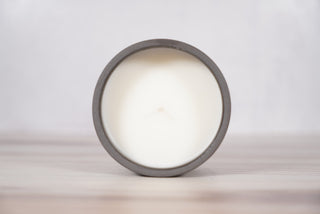 Black spiderweb pattern candle on dark brown speckled ceramic vessel, fifth view
